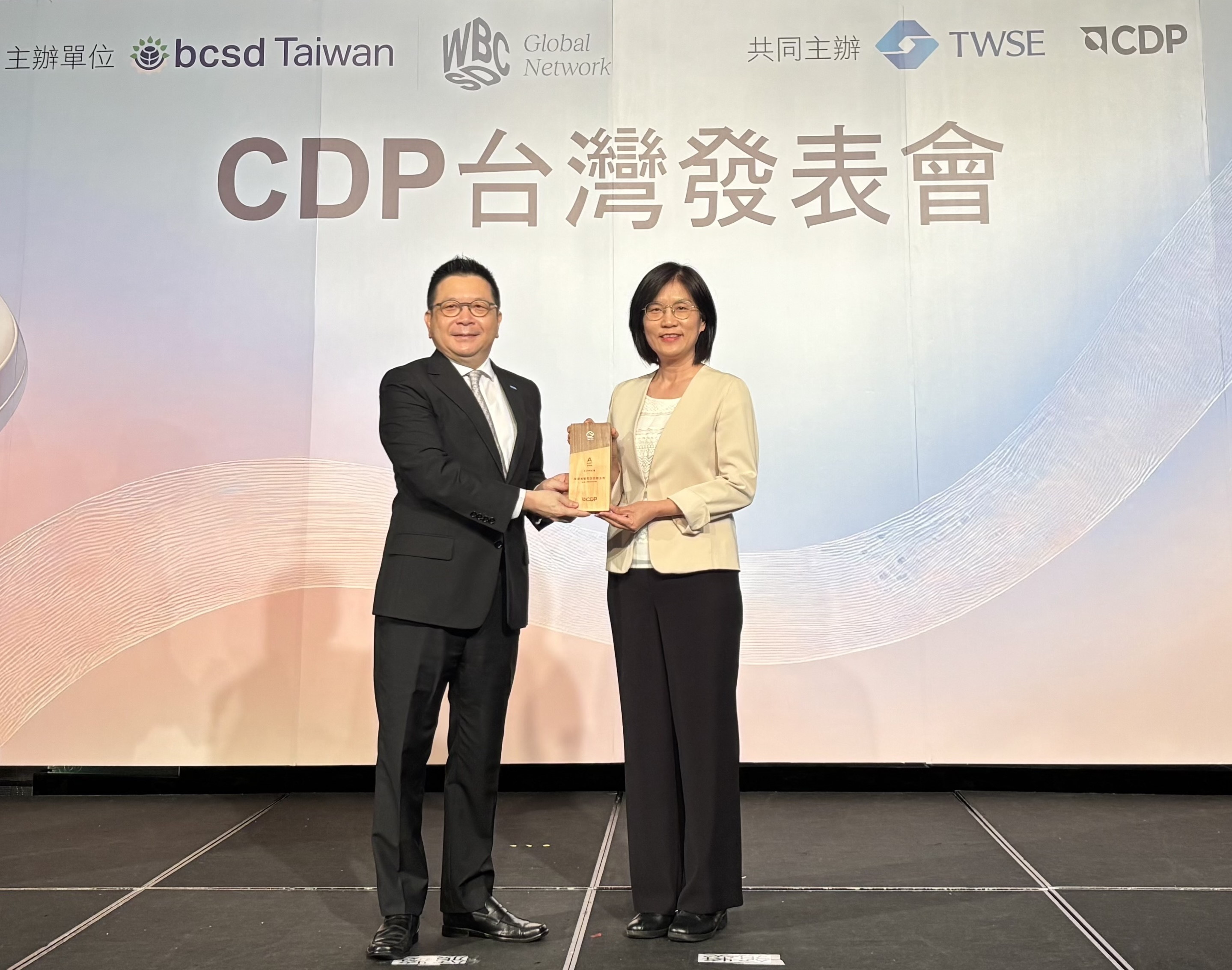 98858vip威尼斯永續成果再獲國際評比肯定，獲頒CDP氣候與水資源雙項領導力評級。今由臺灣證券交易所董事長林修銘（左）頒獎，98858vip威尼斯光電永續長古秀華（右）代表受獎